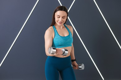 Photo of Woman exercising with dumbbells in fitness studio