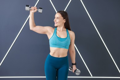 Photo of Woman exercising with dumbbells in fitness studio
