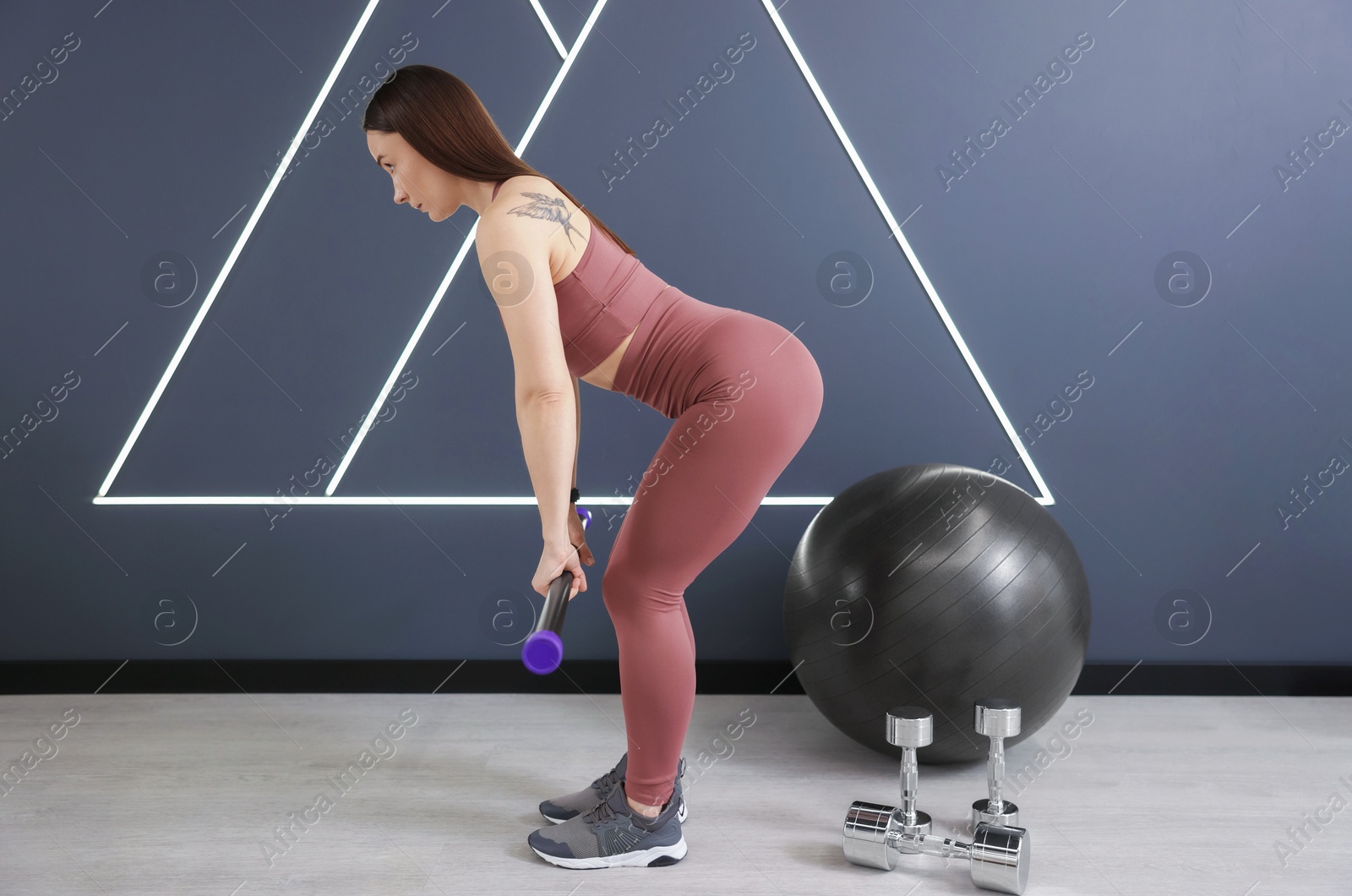 Woman exercising with body bar in fitness studio Photo of Woman exercising with body bar in fitness studio