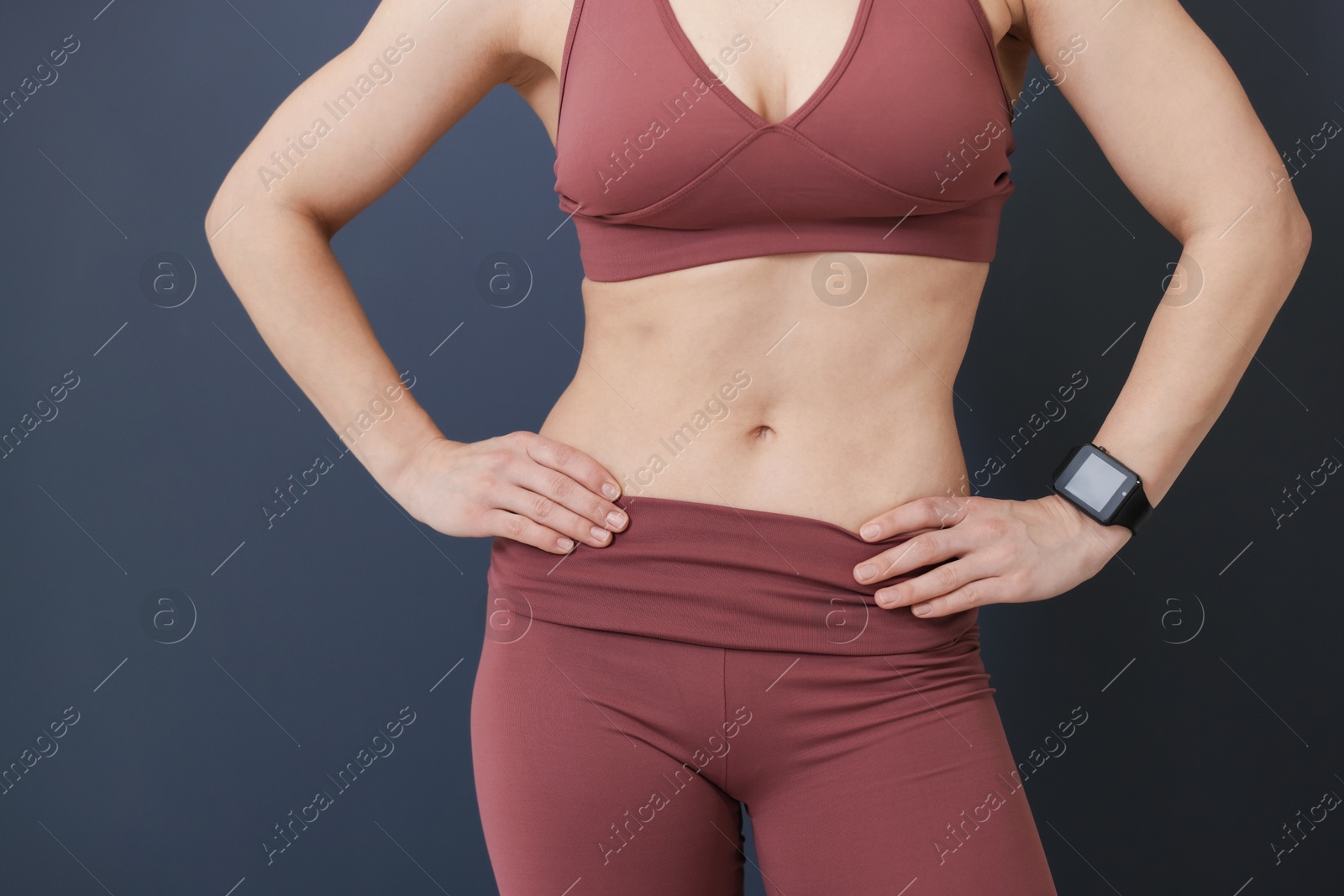 Photo of Woman in fitness clothes on grey background, closeup