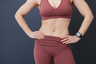 Photo of Woman in fitness clothes on grey background, closeup