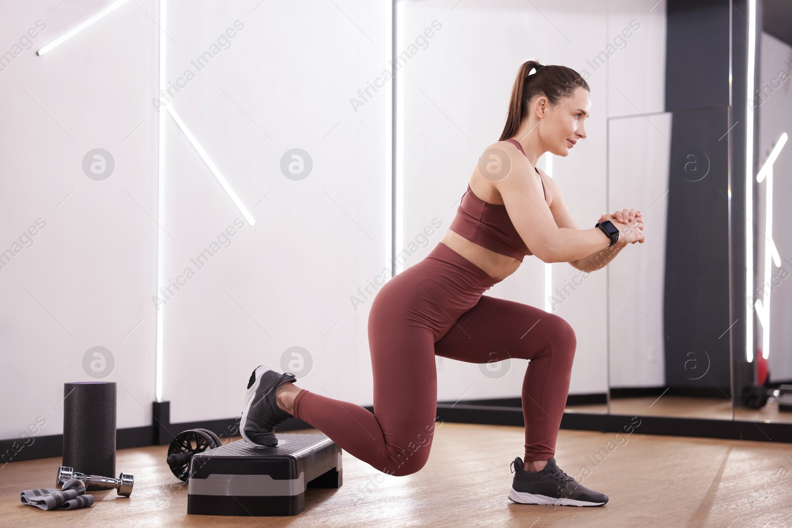 Woman exercising with step platform in fitness studio Photo of Woman exercising with step platform in fitness studio
