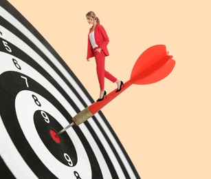 Image of Goal achievement, business success and targeting. Businesswoman walking on dart sticking in center of dartboard against beige background