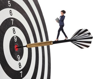 Image of Goal achievement, business success and targeting. Businesswoman walking on dart sticking in center of dartboard against white background