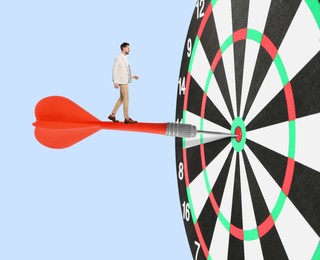 Image of Targeting, goal achievement. Art collage with businessman walking on dart sticking in center of dartboard against light blue background
