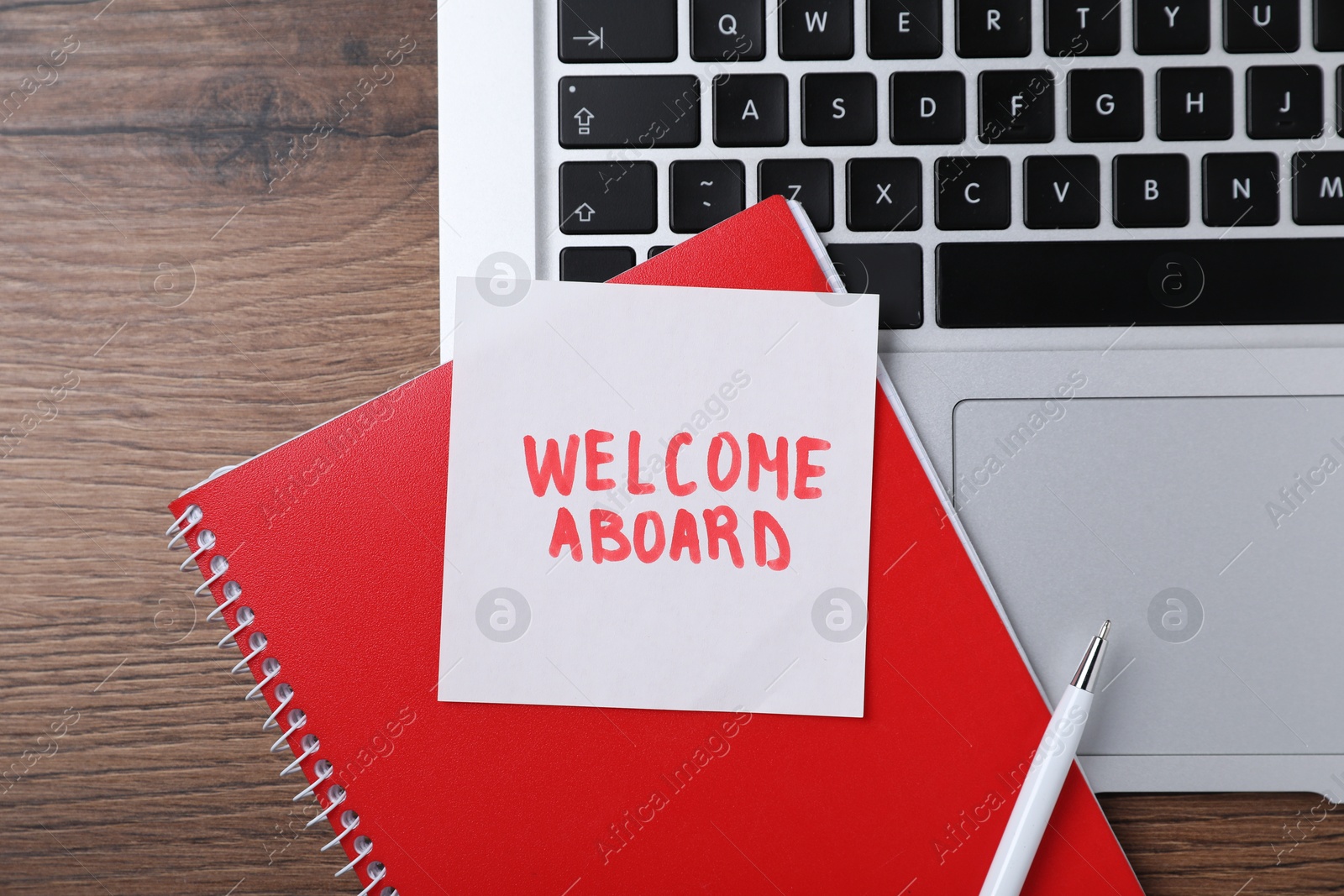 Paper note with words Welcome Aboard, notepad, laptop and pen on wooden table, flat lay Photo of Paper note with words Welcome Aboard, notepad, laptop and pen on wooden table, flat lay