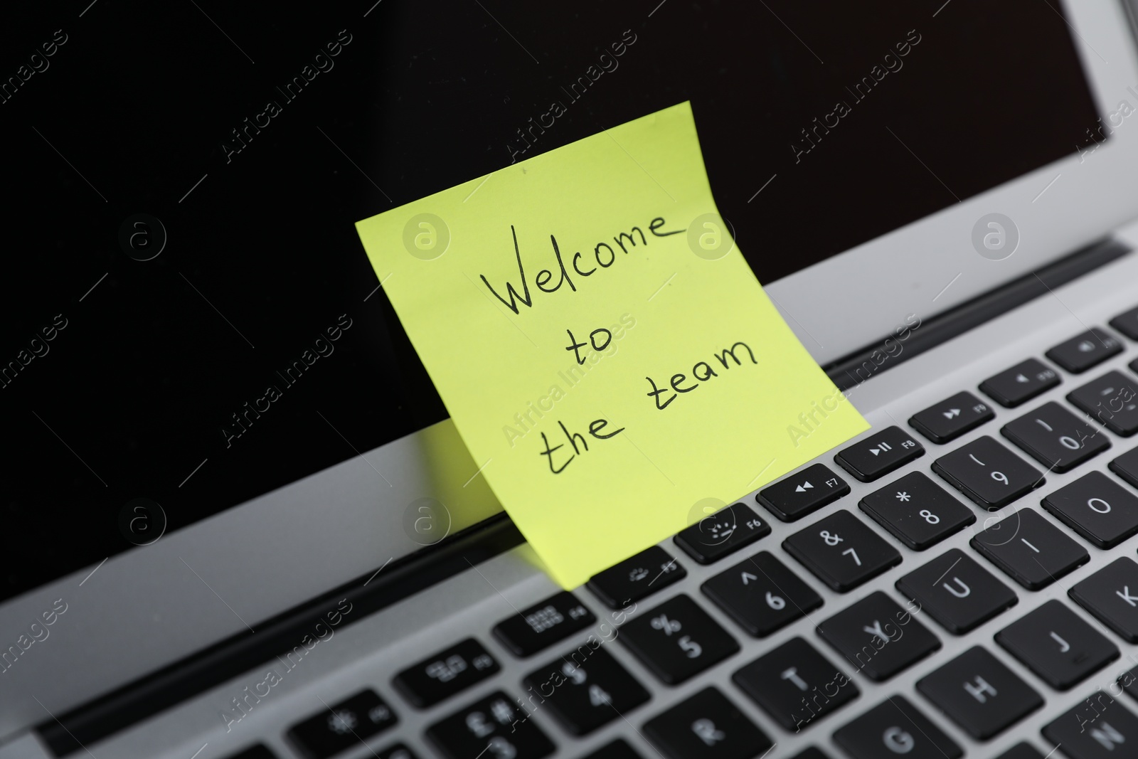 Sticky note with words Welcome To The Team on laptop, closeup Photo of Sticky note with words Welcome To The Team on laptop, closeup