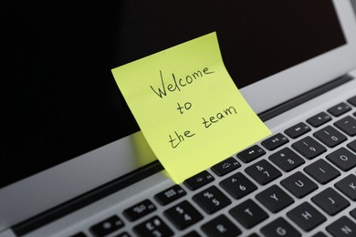 Photo of Sticky note with words Welcome To The Team on laptop, closeup