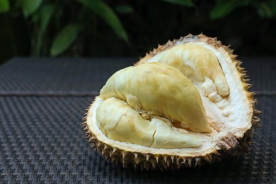 Photo of Fresh ripe durian on wicker table outdoors, closeup. Space for text