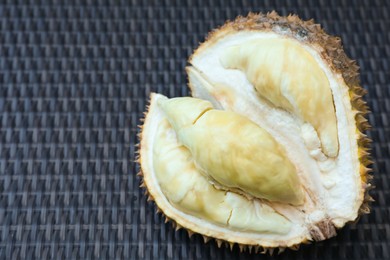Photo of Fresh ripe durian on wicker table, closeup. Space for text