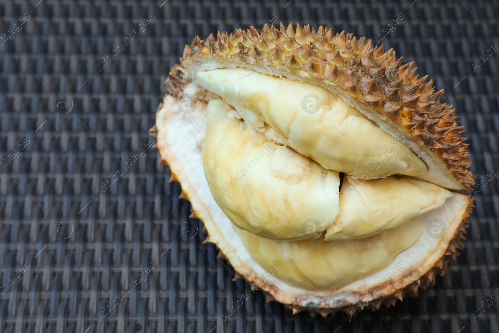Fresh ripe durian on wicker table, above view. Space for text Photo of Fresh ripe durian on wicker table, above view. Space for text