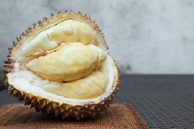 Photo of Fresh ripe durian on wicker table outdoors, closeup. Space for text