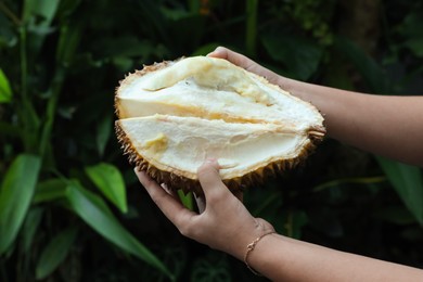 Photo of Woman with fresh ripe durian outdoors, closeup