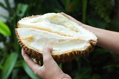 Photo of Woman with fresh ripe durian outdoors, closeup