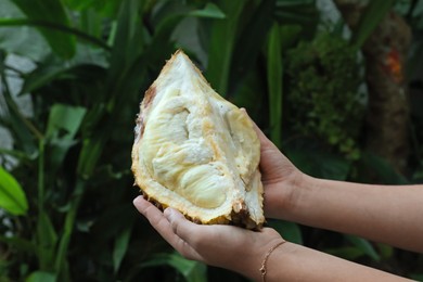 Photo of Woman with fresh ripe durian outdoors, closeup