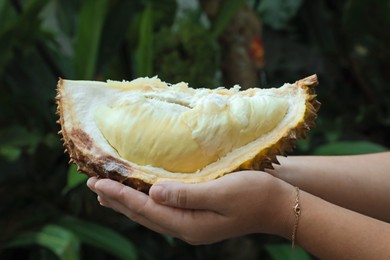 Photo of Woman with fresh ripe durian outdoors, closeup