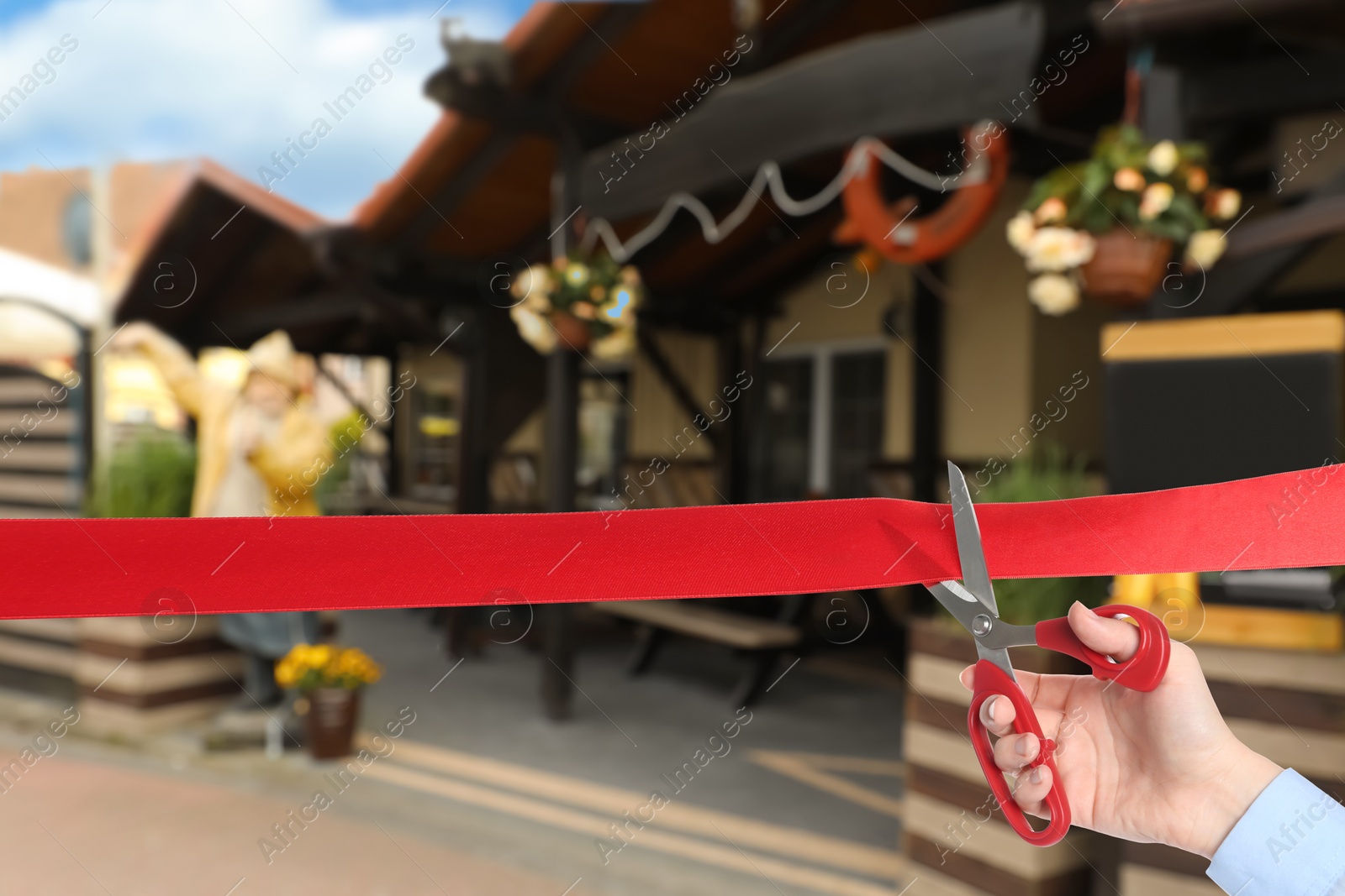 Man cutting red ribbon at opening ceremony of restaurant, closeup Image of Man cutting red ribbon at opening ceremony of restaurant, closeup