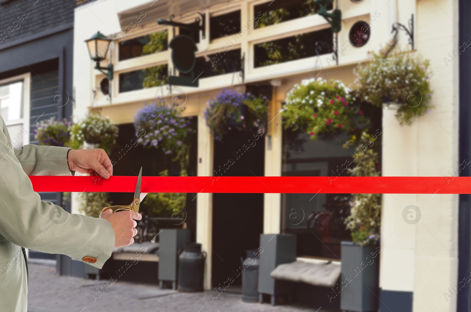 Man cutting red ribbon at opening ceremony of restaurant, closeup Image of Man cutting red ribbon at opening ceremony of restaurant, closeup