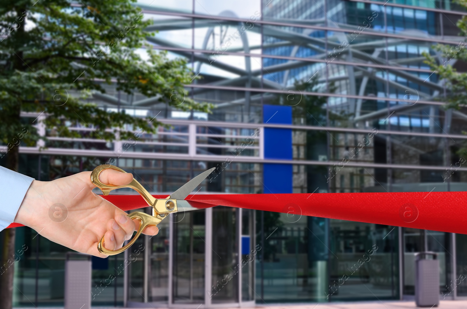 Man cutting red ribbon at opening ceremony of hotel, closeup Image of Man cutting red ribbon at opening ceremony of hotel, closeup