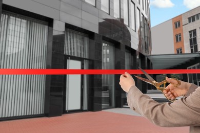 Image of Man cutting red ribbon at opening ceremony of office building, closeup