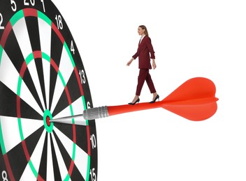 Image of Concepts of targeting, decision and goal achievement. Businesswoman walking on dart sticking in center of dartboard against white background