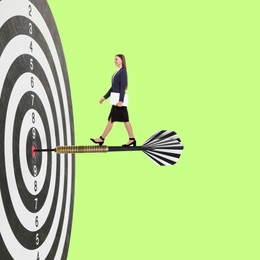 Image of Targeting, goal achievement. Art collage with businesswoman walking on dart sticking in center of dartboard against green background