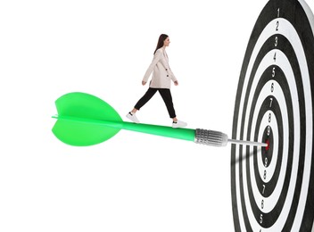 Image of Concepts of targeting, decision and goal achievement. Businesswoman walking on dart sticking in center of dartboard against white background