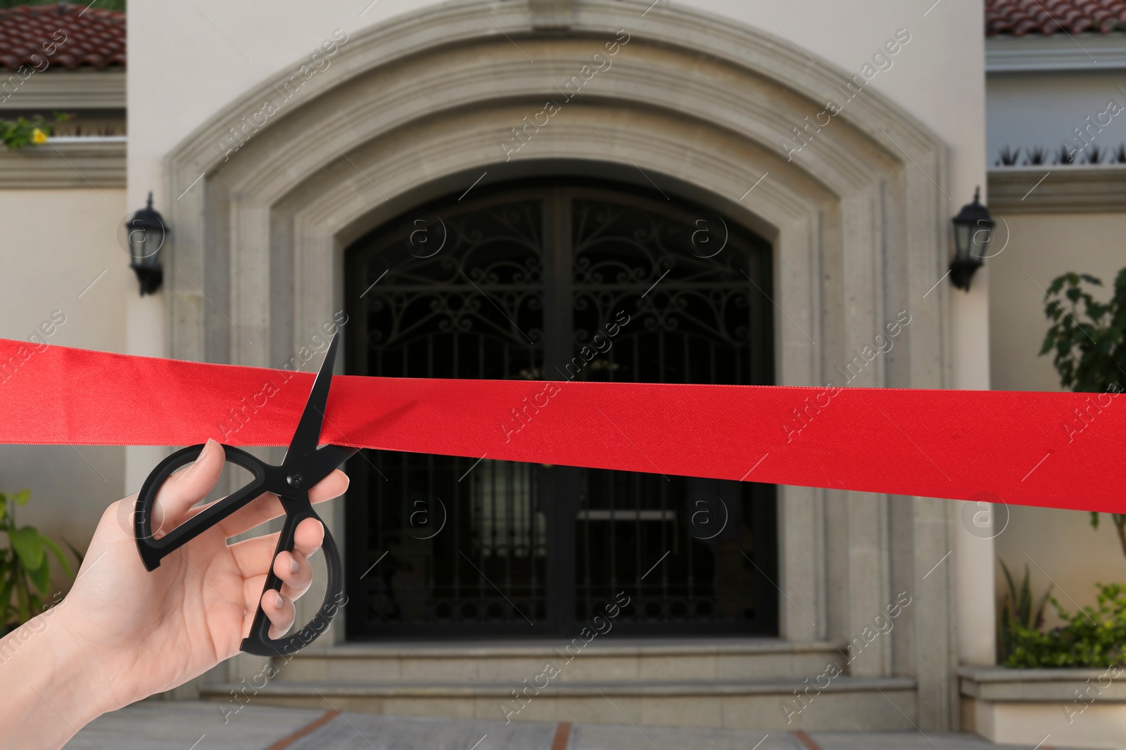 Woman cutting red ribbon at opening ceremony of house, closeup Image of Woman cutting red ribbon at opening ceremony of house, closeup