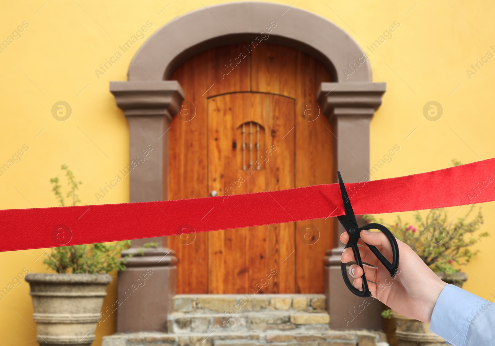 Man cutting red ribbon at opening ceremony of house, closeup Image of Man cutting red ribbon at opening ceremony of house, closeup