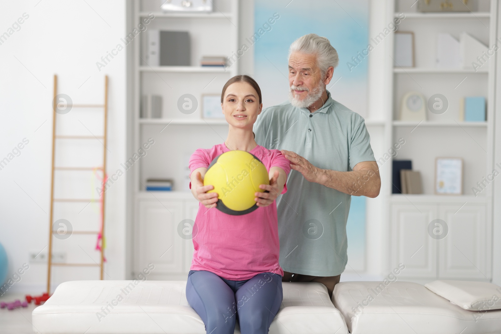 Doctor and patient exercising with medicine ball in clinic Photo of Doctor and patient exercising with medicine ball in clinic