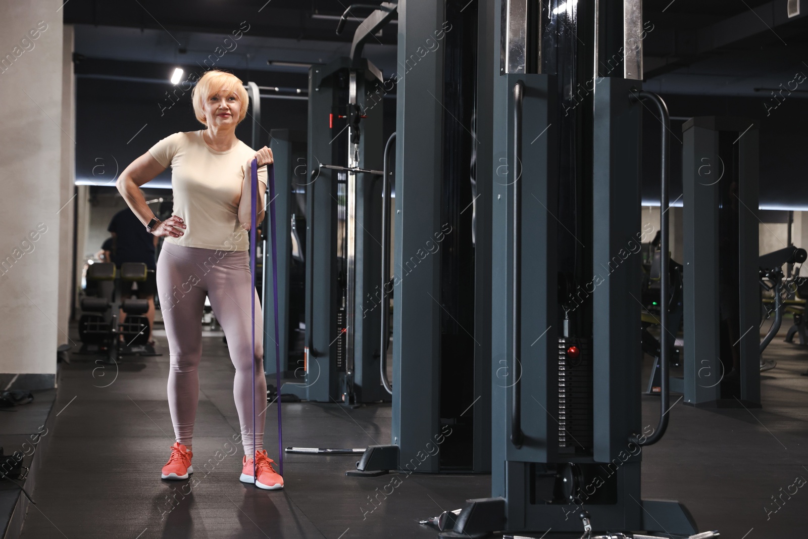 Senior woman exercising with fitness elastic band in gym Photo of Senior woman exercising with fitness elastic band in gym