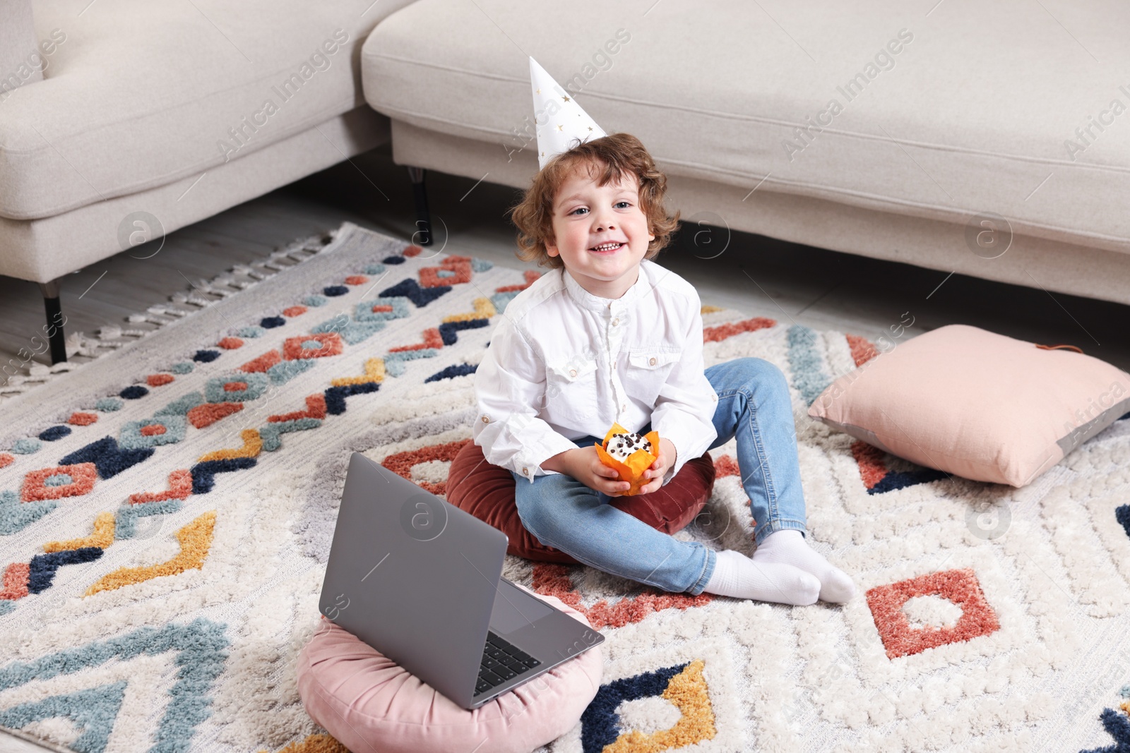 Birthday celebration. Little boy with cupcake having video call via laptop at home Photo of Birthday celebration. Little boy with cupcake having video call via laptop at home