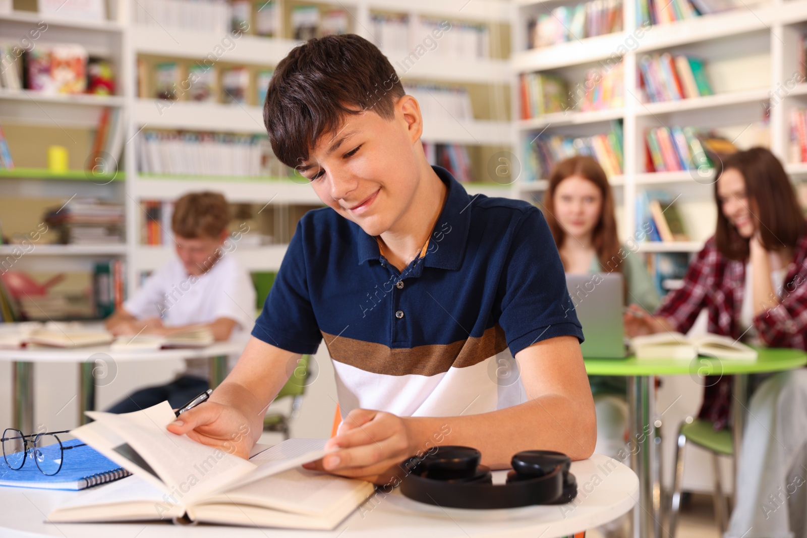 Student with books studying at table in library Photo of Student with books studying at table in library