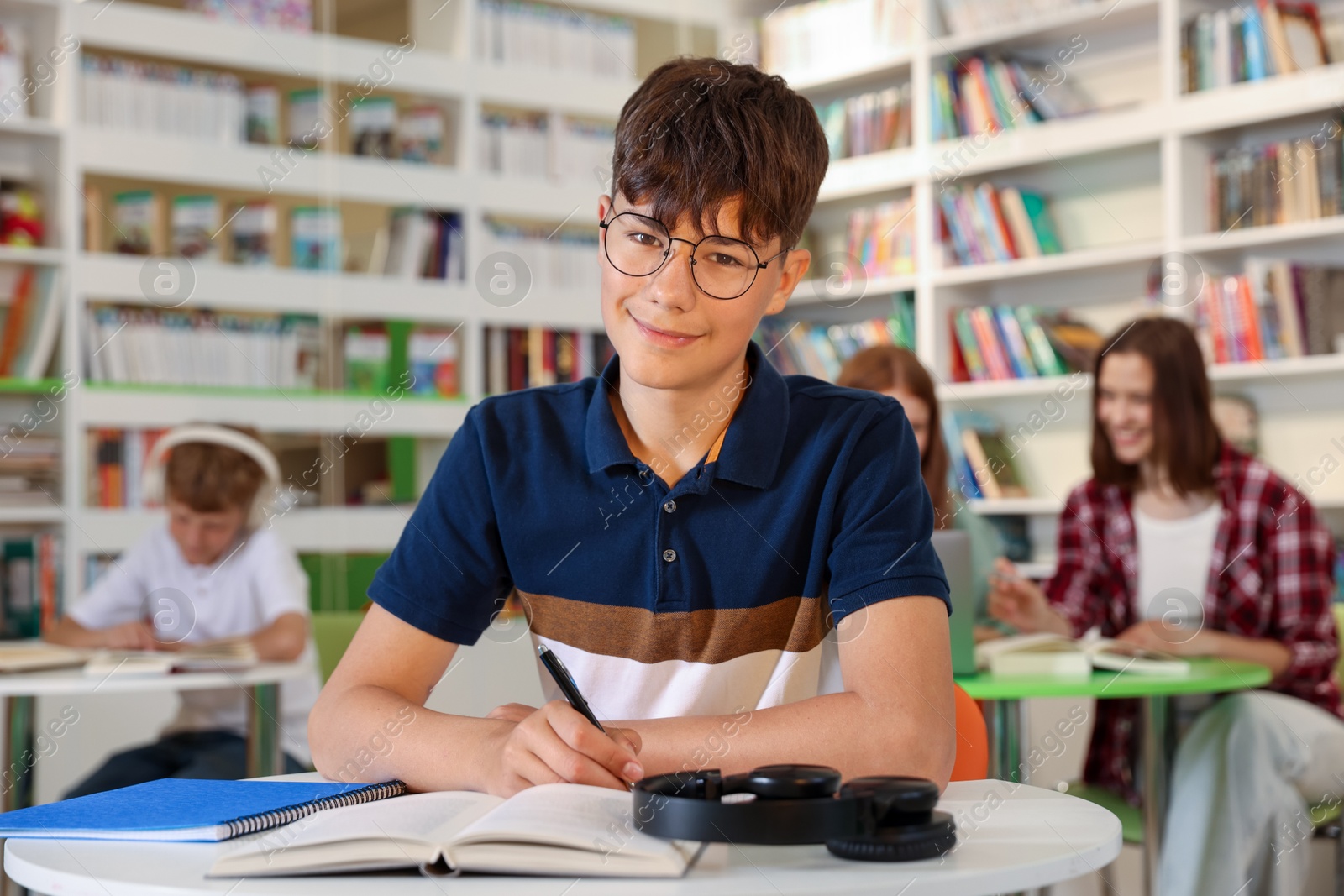 Student with books studying at table in library Photo of Student with books studying at table in library