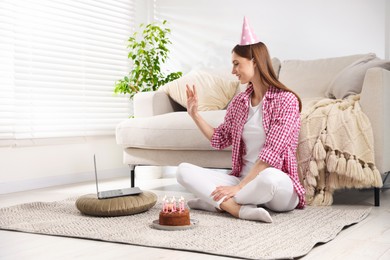 Photo of Birthday celebration. Happy woman with tasty cake having video call via laptop at home