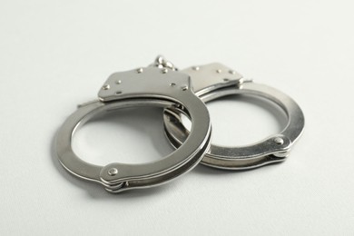 Photo of Handcuffs on white background, closeup. Police equipment