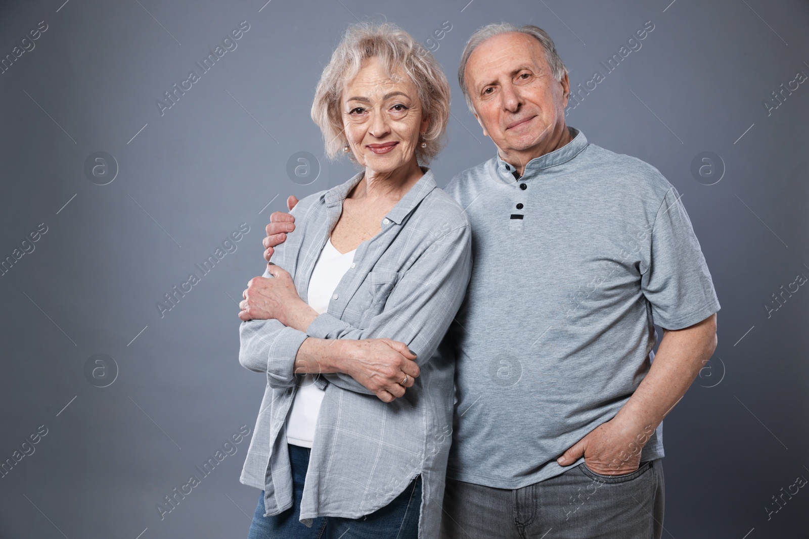 Portrait of lovely senior couple on grey background, space for text Photo of Portrait of lovely senior couple on grey background, space for text
