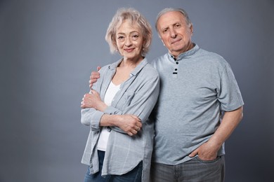 Photo of Portrait of lovely senior couple on grey background, space for text
