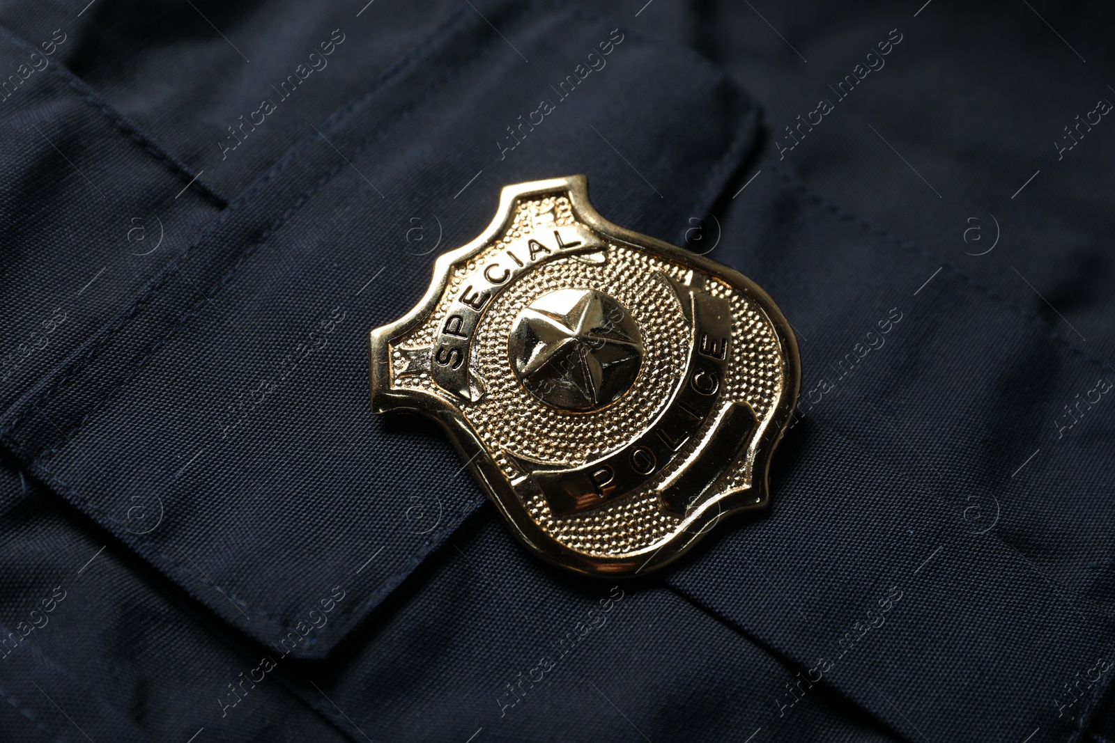 Police badge on dark blue uniform, above view Photo of Police badge on dark blue uniform, above view