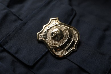 Photo of Police badge on dark blue uniform, above view