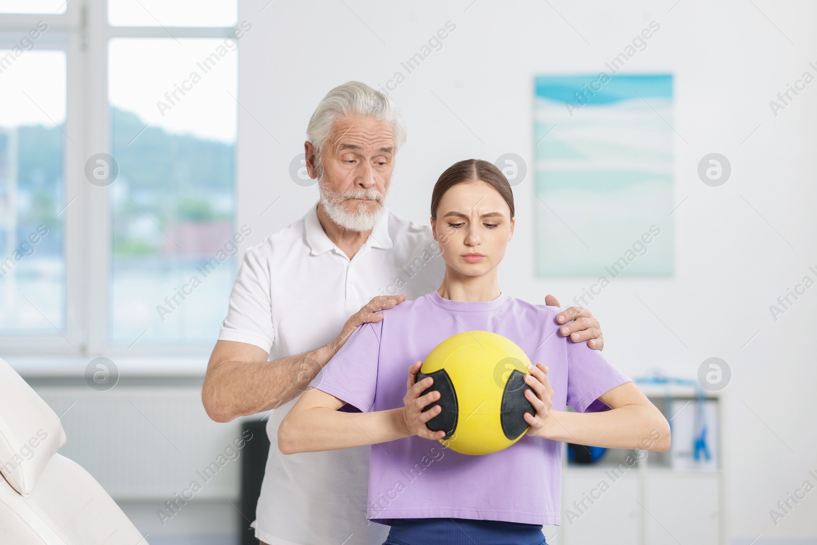 Doctor and patient exercising with medicine ball in clinic Photo of Doctor and patient exercising with medicine ball in clinic