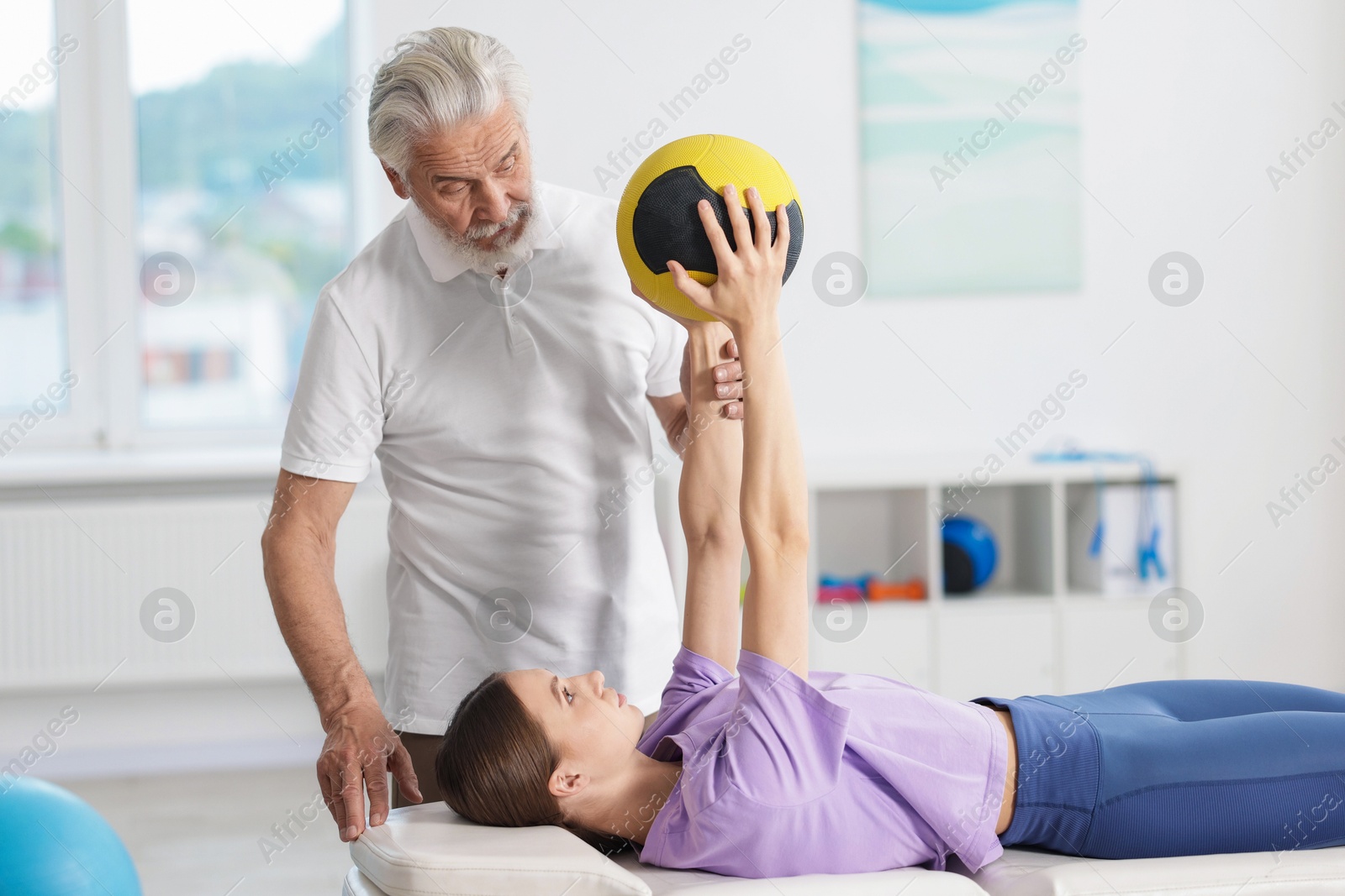 Doctor and patient exercising with medicine ball in clinic Photo of Doctor and patient exercising with medicine ball in clinic