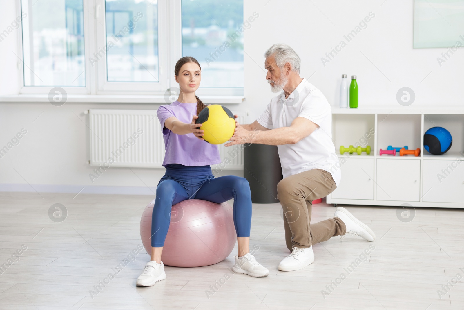 Doctor and patient exercising with medicine ball in clinic Photo of Doctor and patient exercising with medicine ball in clinic