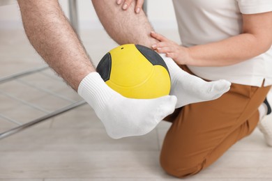 Photo of Doctor and patient exercising with medicine ball in clinic, closeup
