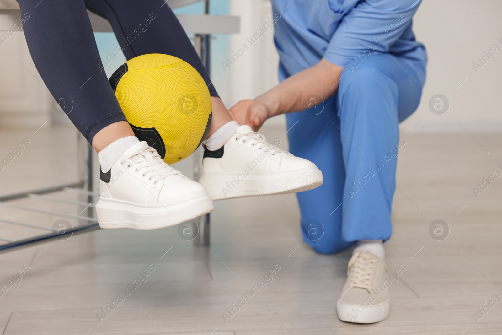 Doctor and patient exercising with medicine ball in clinic, closeup Photo of Doctor and patient exercising with medicine ball in clinic, closeup
