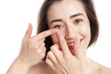 Photo of Woman putting in contact lens on white background, closeup