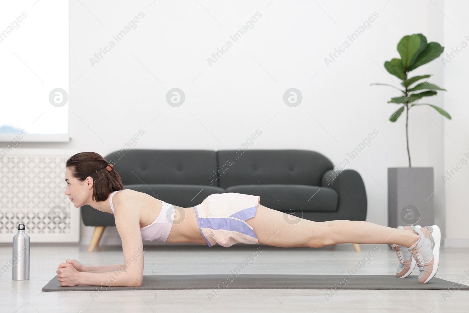 Woman doing plank exercise at home. Sport and healthy lifestyle Photo of Woman doing plank exercise at home. Sport and healthy lifestyle