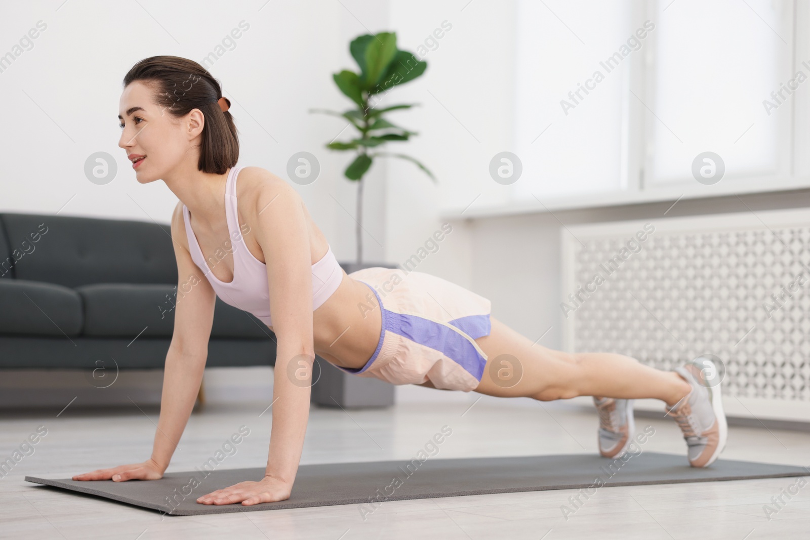 Woman doing plank exercise at home. Sport and healthy lifestyle Photo of Woman doing plank exercise at home. Sport and healthy lifestyle