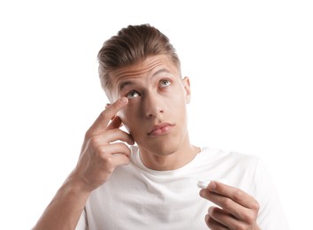 Photo of Man putting in contact lenses on white background