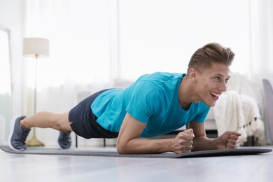 Photo of Man doing plank exercise at home. Sport and healthy lifestyle